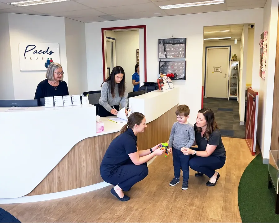 Two Paeds Plus clinicians greeting a young boy at the Currambine reception